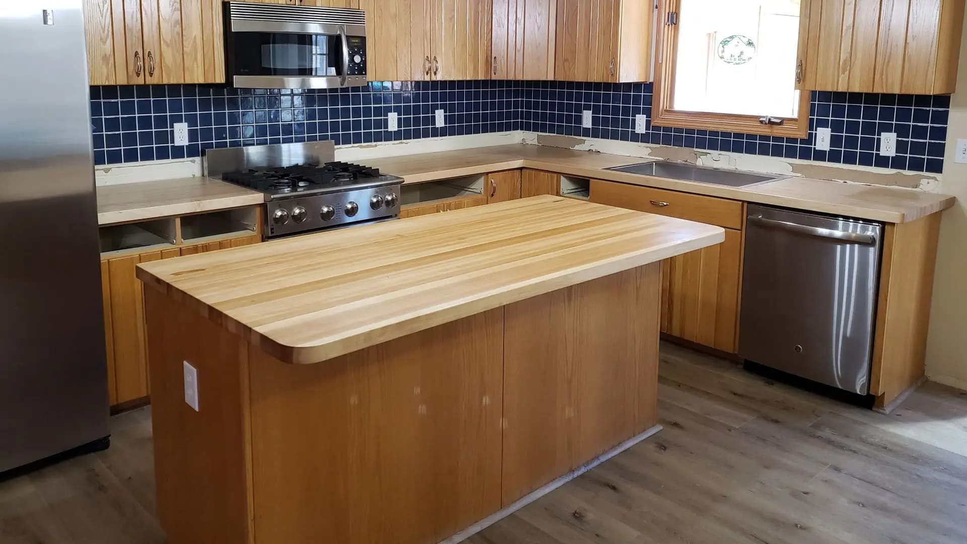 a kitchen with wood cabinets and a wood countertop