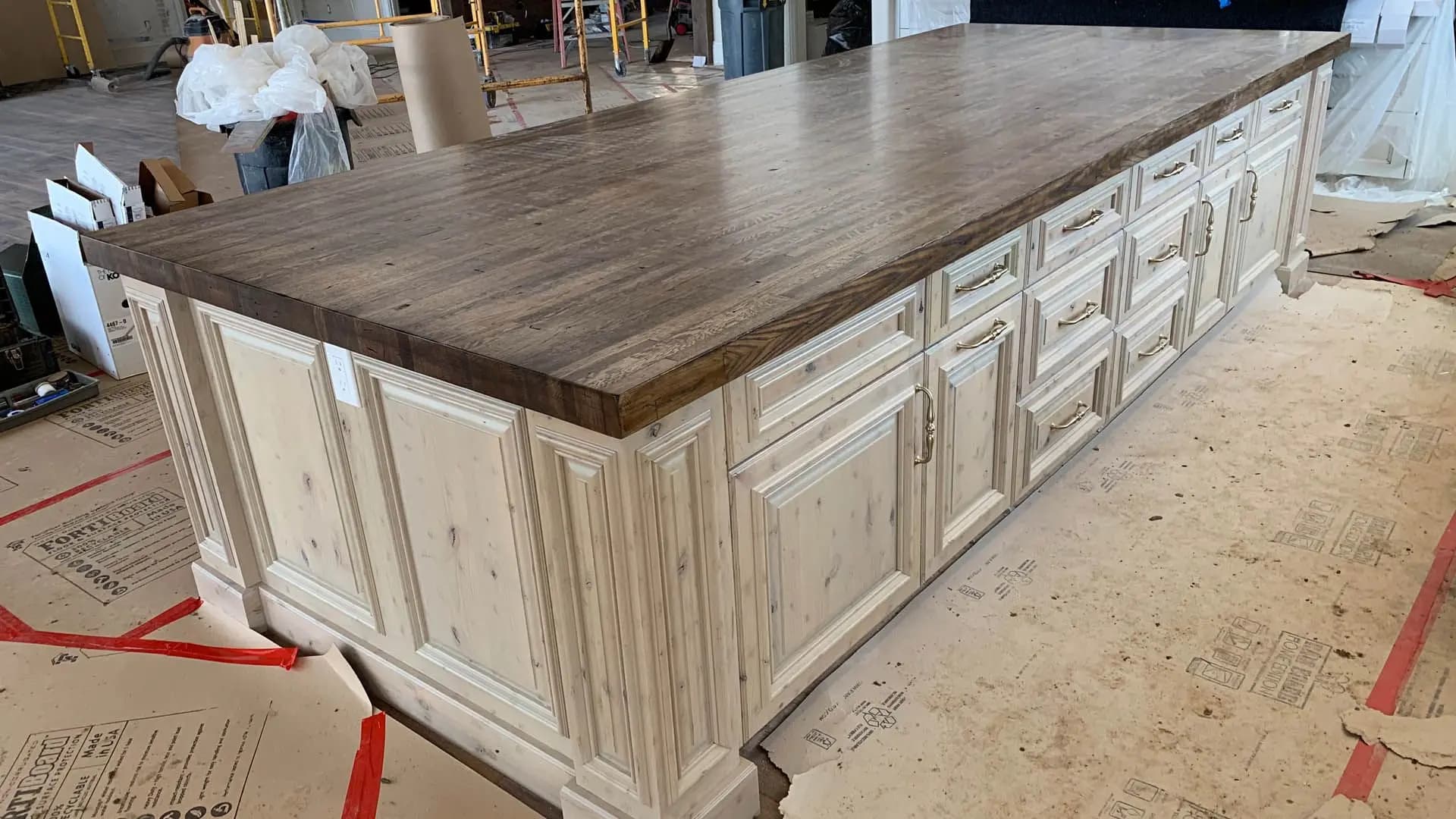 a kitchen island with drawers and a wood top