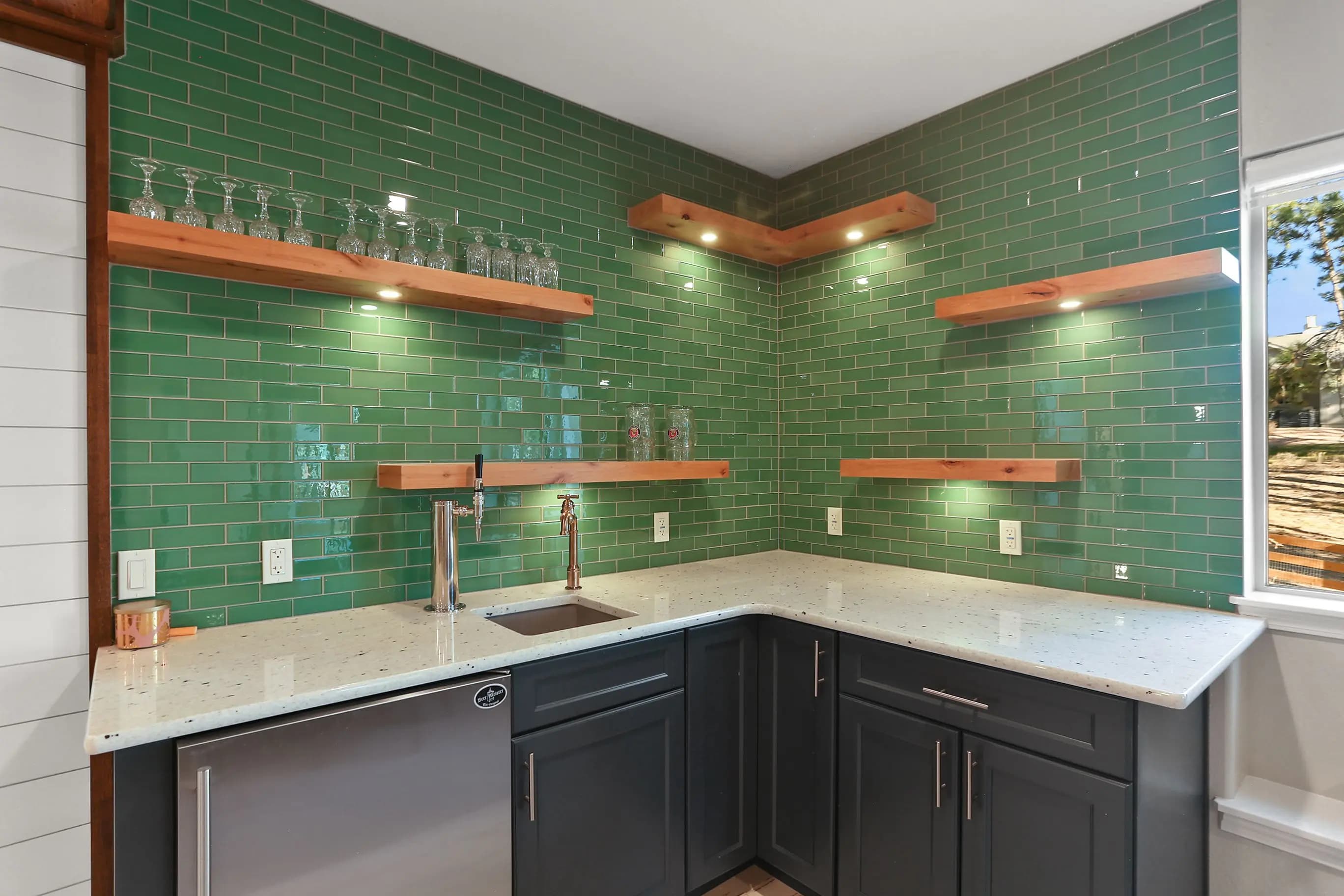 a shelf with glasses and a green wall