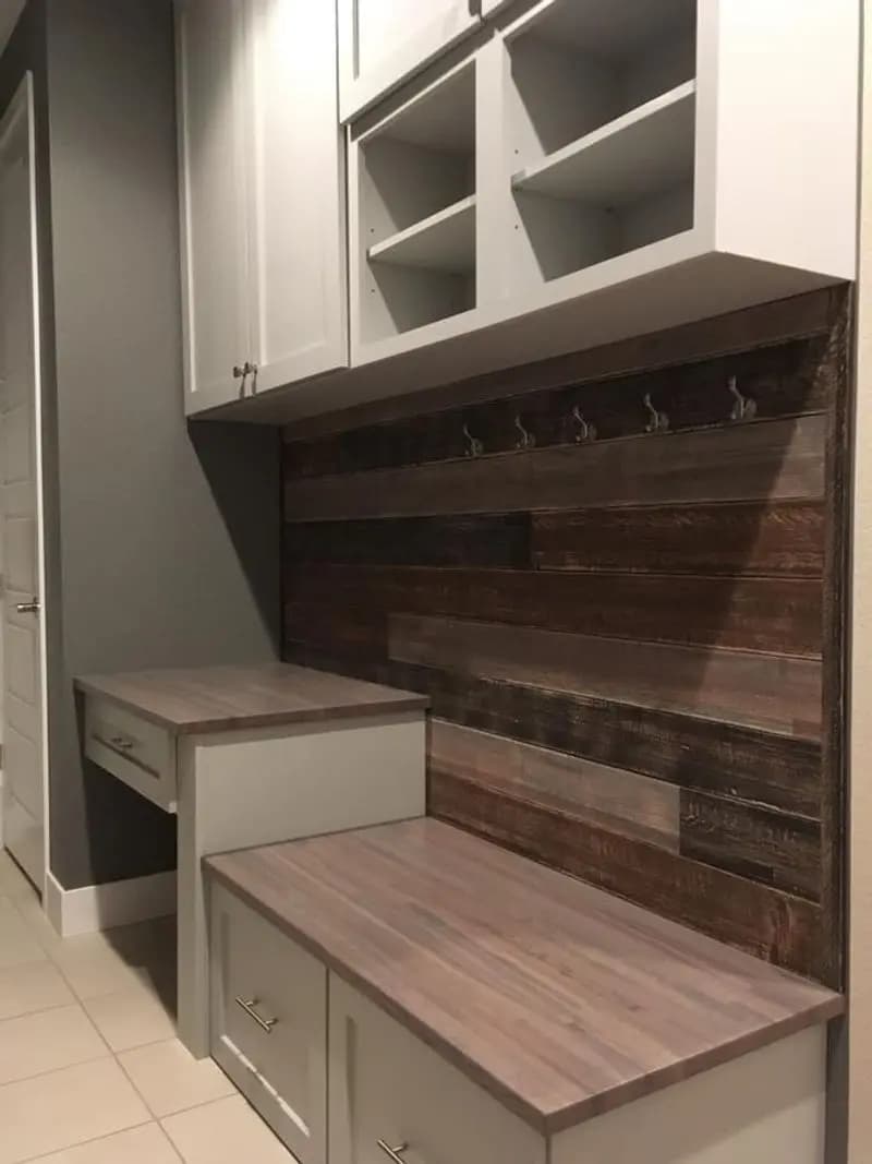 a white cabinets and bench in a room