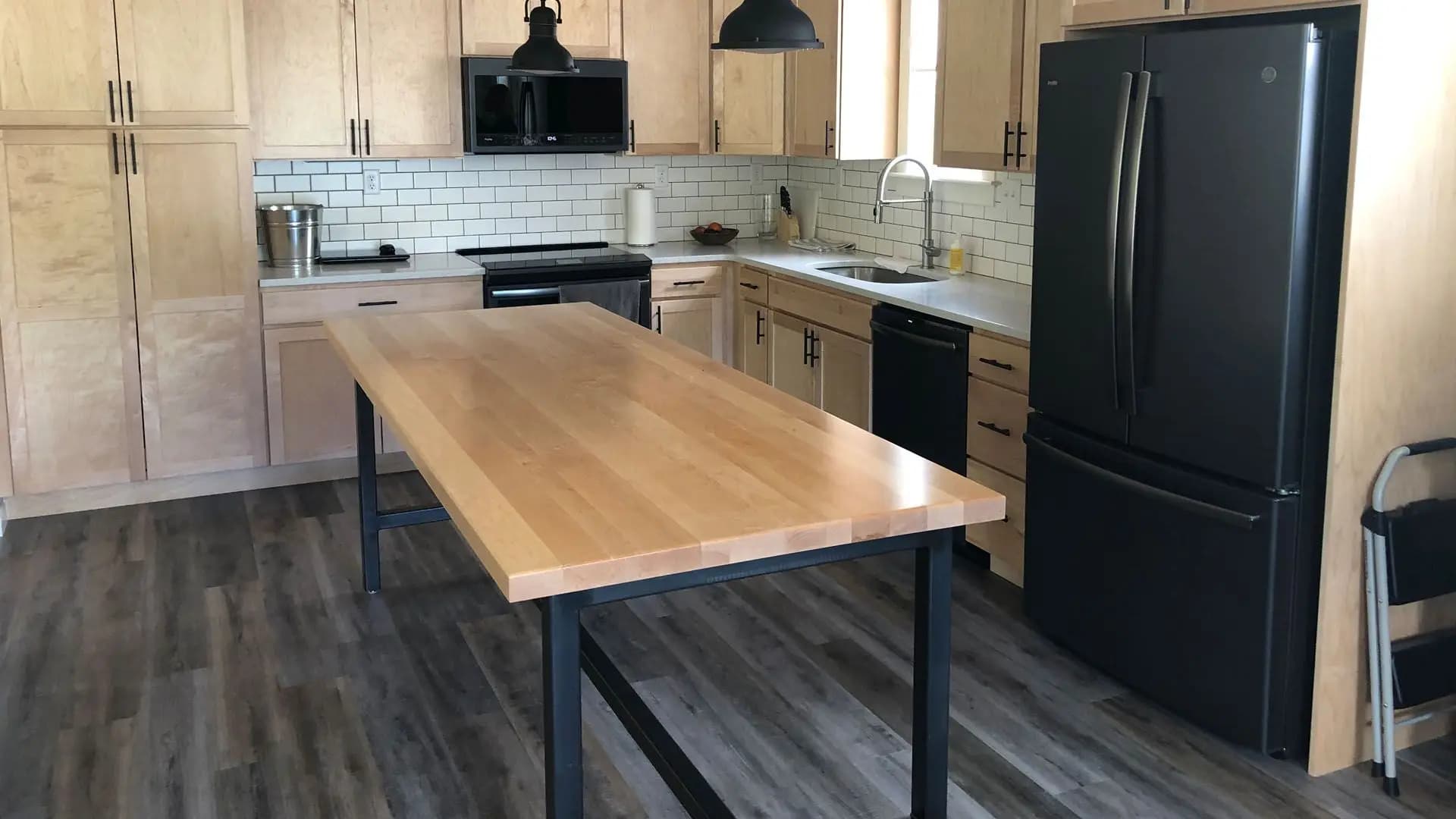 a kitchen with a table and black appliances