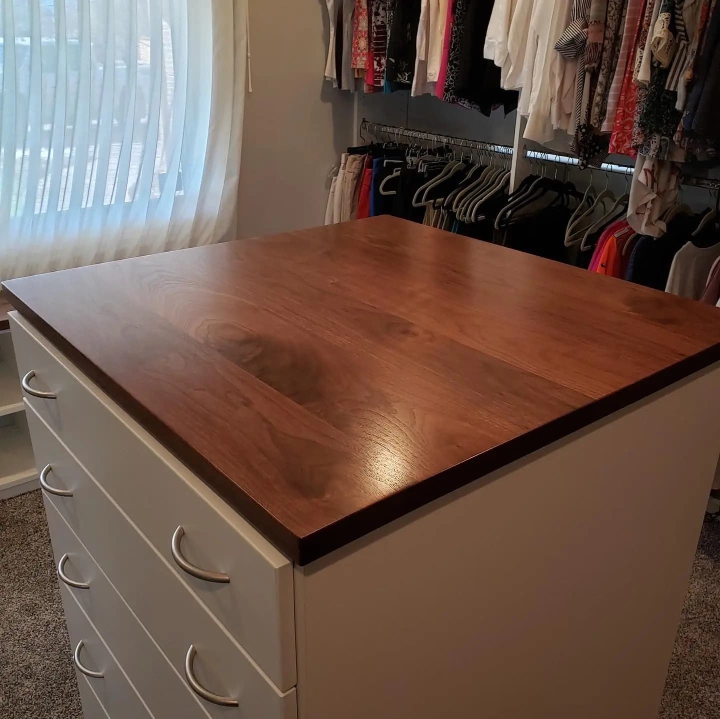 a closet with a wooden table and drawers