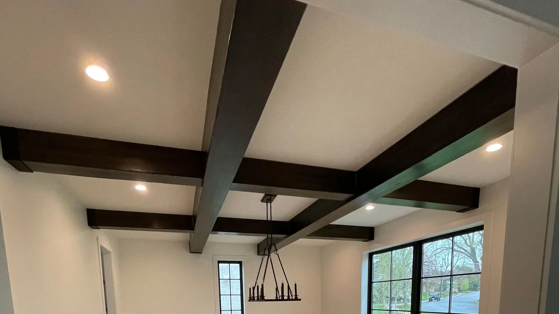 a ceiling with beams and a chandelier