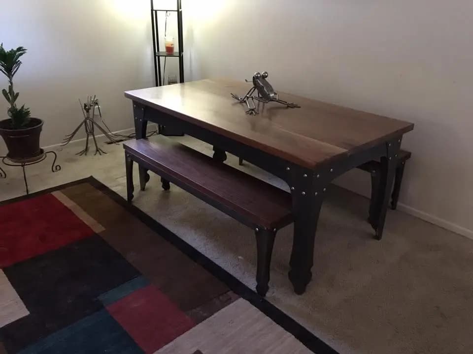 a table with a bench and a metal sculpture on it