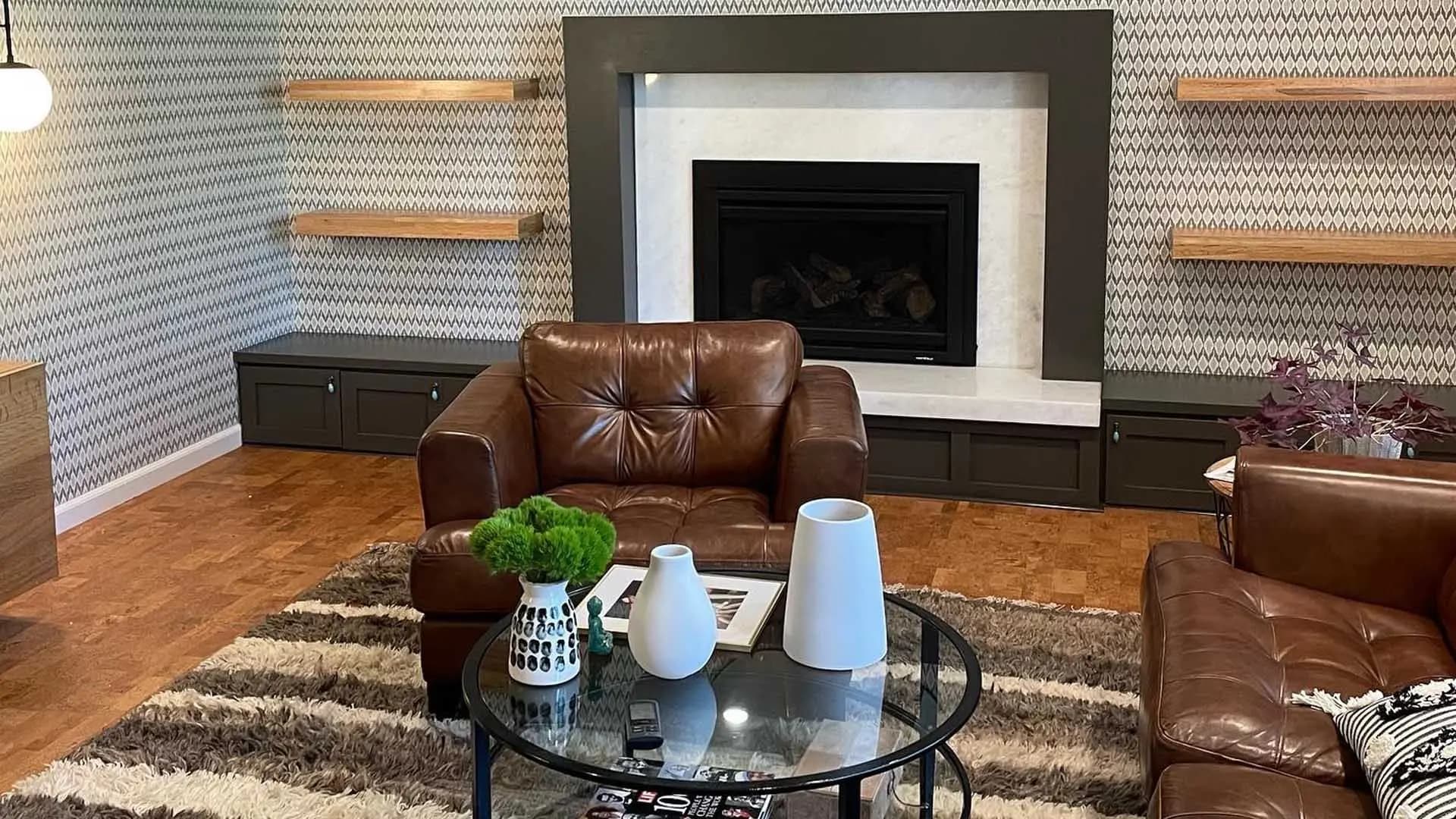 a living room with a leather chair and a fireplace