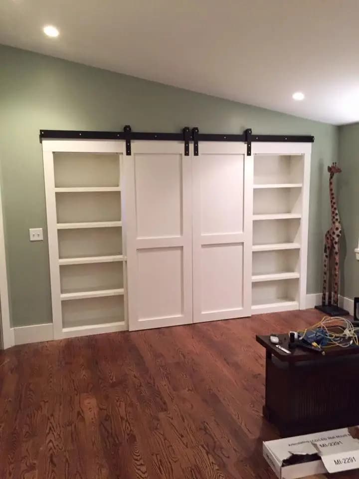 a room with white shelves and a wood floor